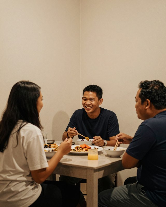 Friends sharing a simple evening meal around a small table, talking together