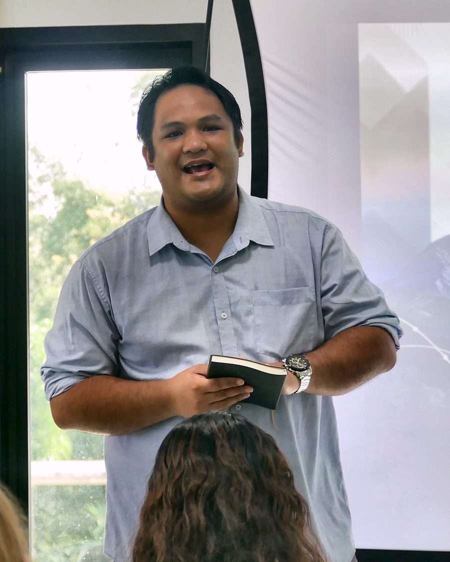Bro. Aldrin Barreto preaching the closing message, an open notebook in his hands, the Summit 2026 slide on the screen behind him.