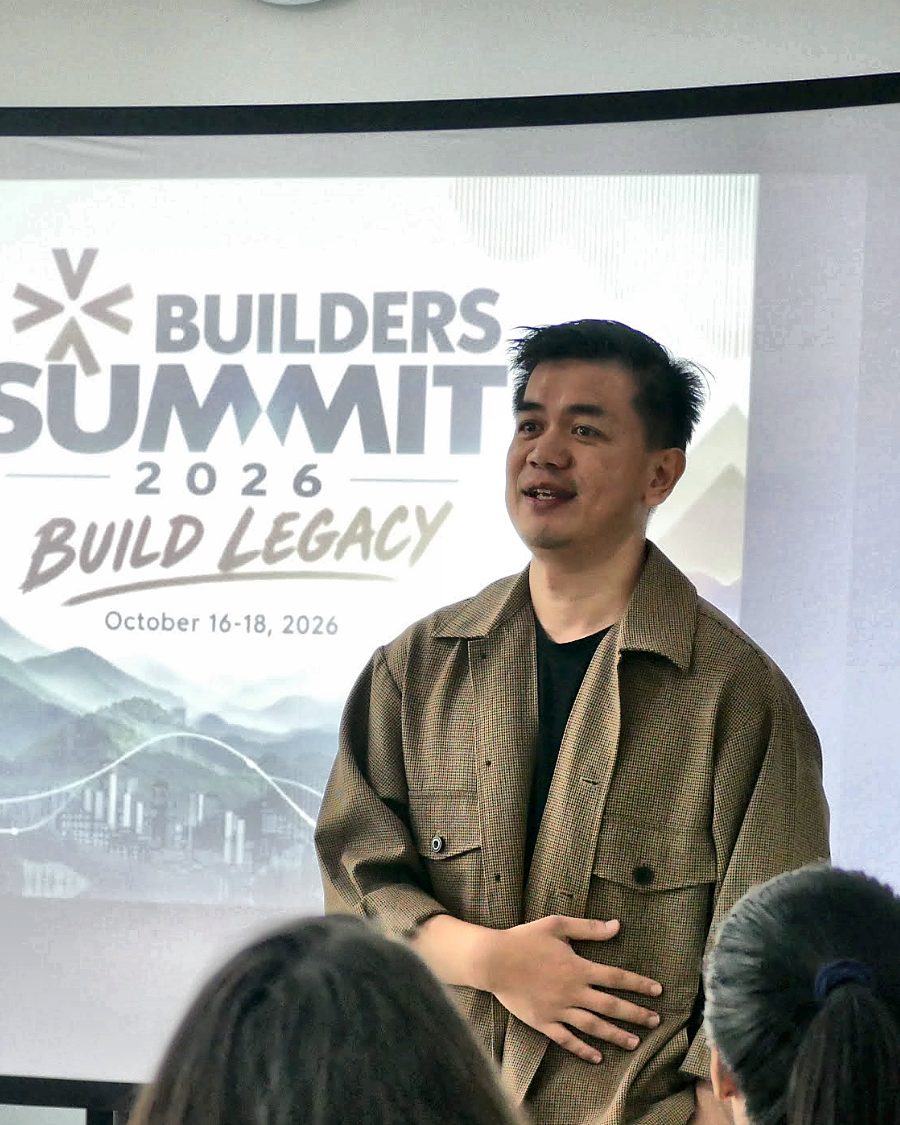 Benson Baniwas speaking at the Builders&rsquo; Summit, standing in front of the projected &ldquo;Build Legacy&rdquo; title slide.